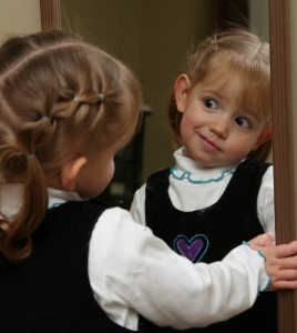 young girl saying her positive affirmations into the mirror